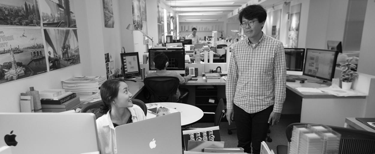 Seung Hwan Namgoong is having a word with Ashley Kim while she works on her computer..