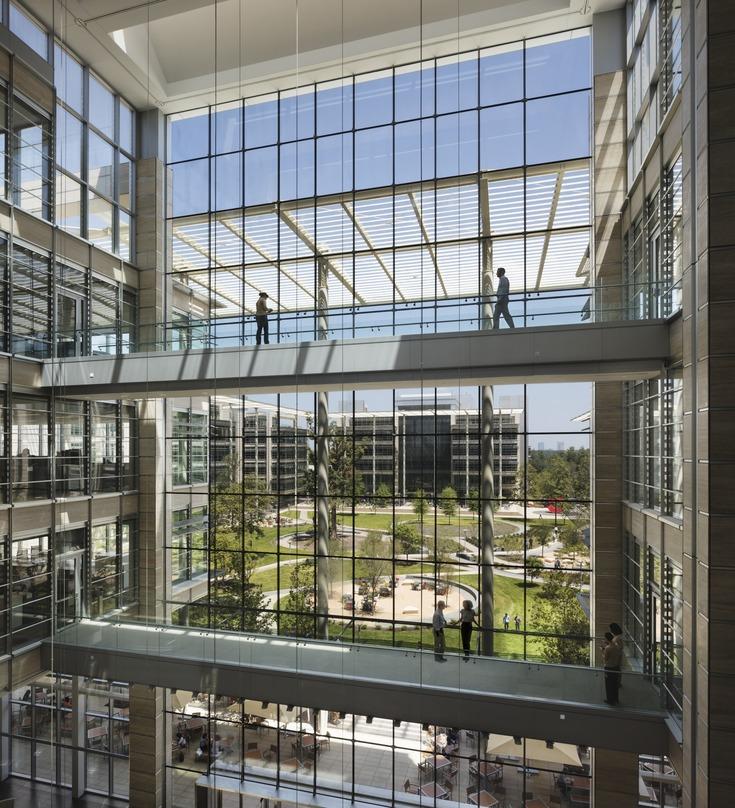 multi-level walways crossing inside the ExxonMobil Office Complex with glass facade looking out at the green campus