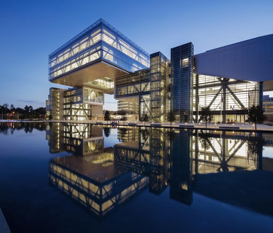 The glass lighted exterior design of the ExxonMobil Energy Center located in Houston, Texas projecting its reflection.