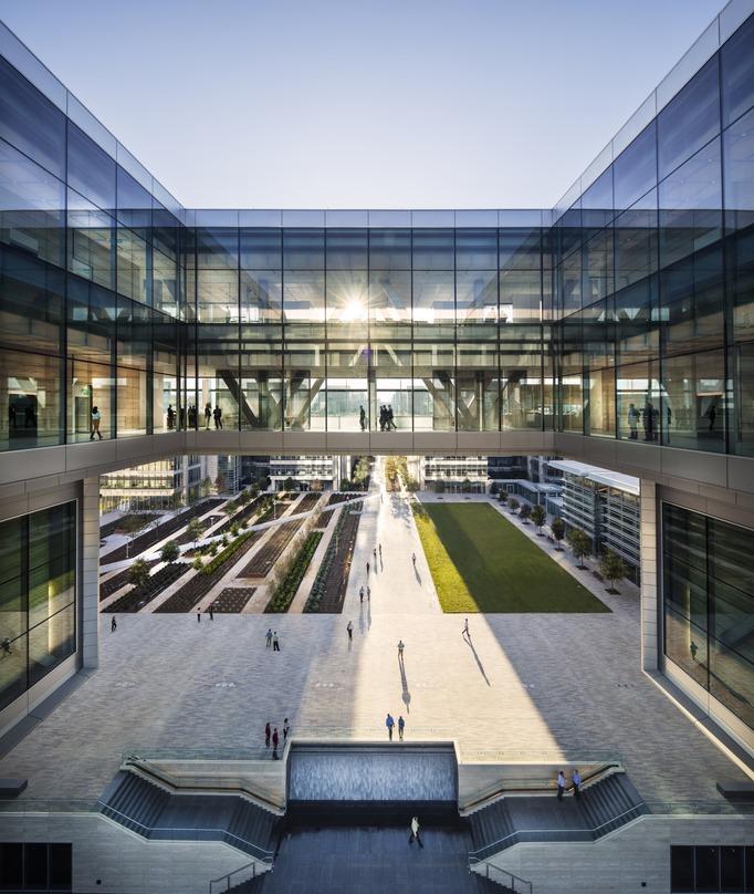 People walking in the symmetrically designed central atrium at the ExxonMobil Energy Center, Houston, Texas.