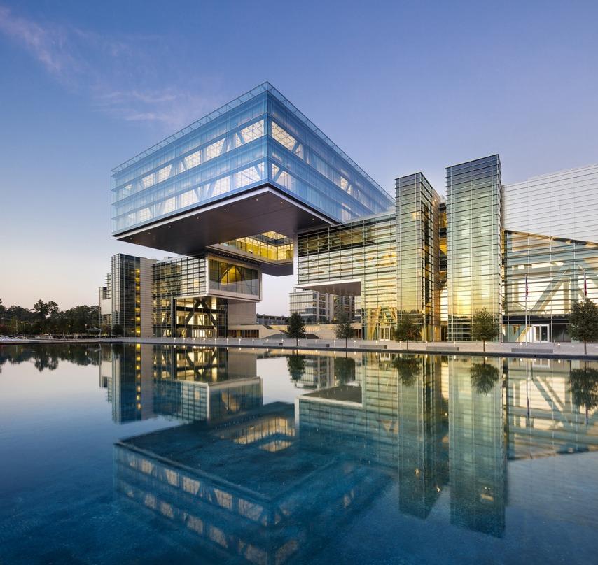 The glass lighted exterior design of the ExxonMobil Energy Center located in Houston, Texas projecting its reflection.