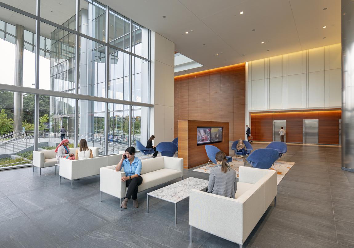 People sitting inside the glass frame walls of the 20-storey 600 Canal Place located in Richmond, Virginia.