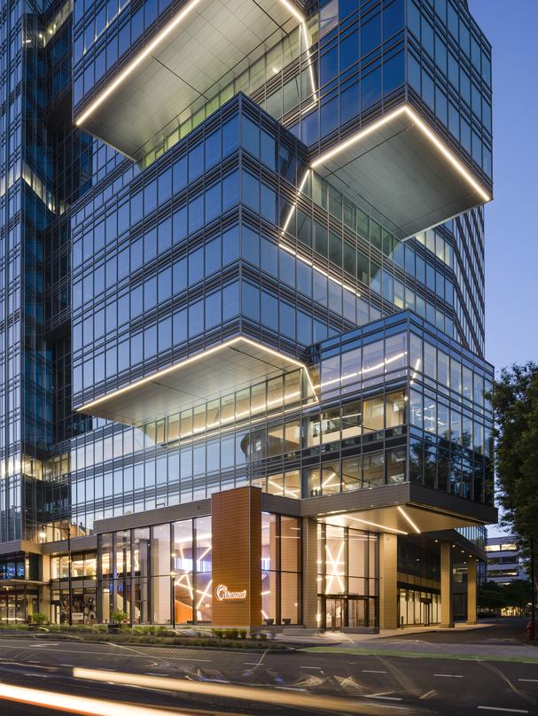 Akamai Headquarters building front entrance view at dusk with lighting that traces underneath the perimiter edge of each extruding cantilever