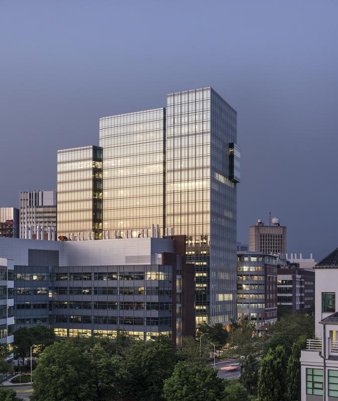 A view of the Akamai Headquarters buuilding at dusk with a dark blue background