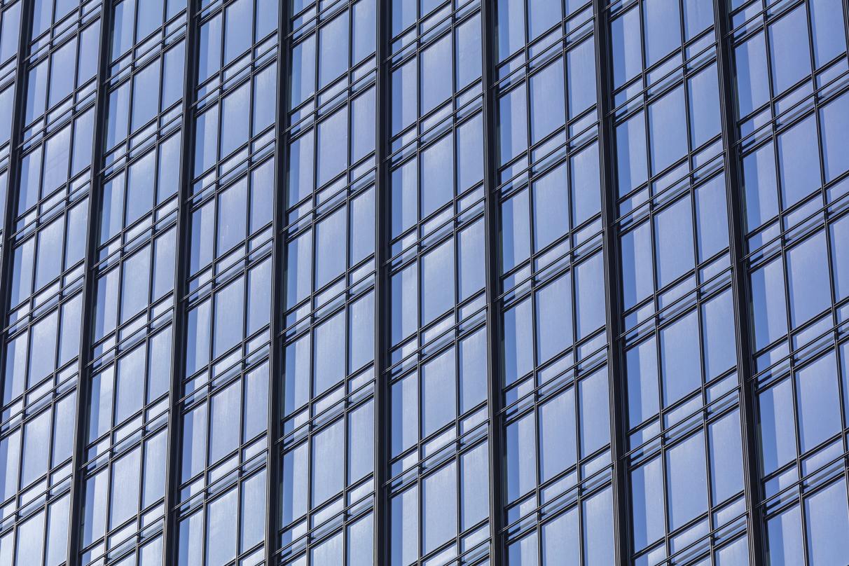 A close up view of the 300 Colorado building which shows the iron railings and glass of the wall