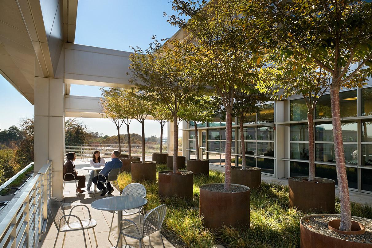 three people sitting and talking outside seating CalPERS Headquarters Complex