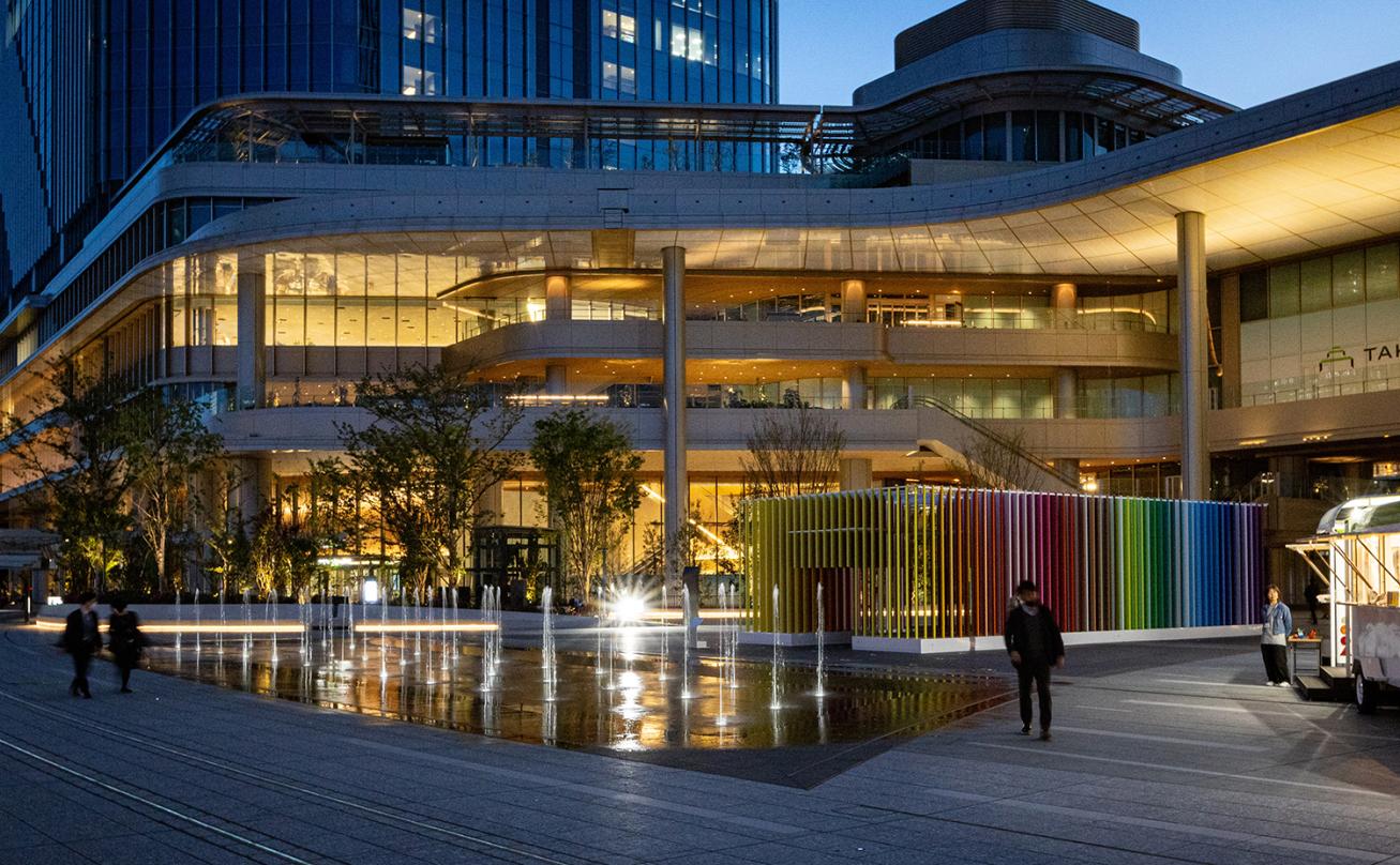 The public plaza of Takanawa Gateway City seen at nighttime illuminated.