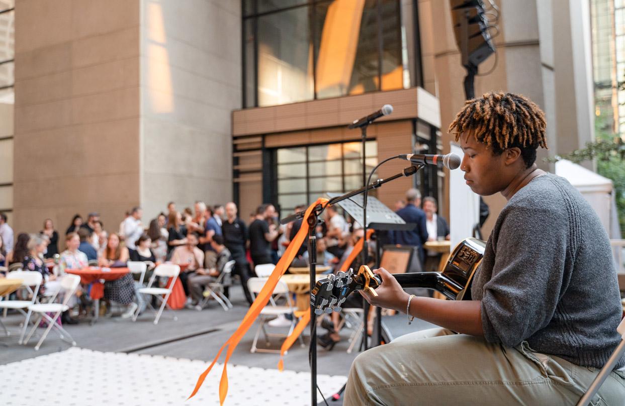 A singer performing to crowds in the public space at 2+U urban village