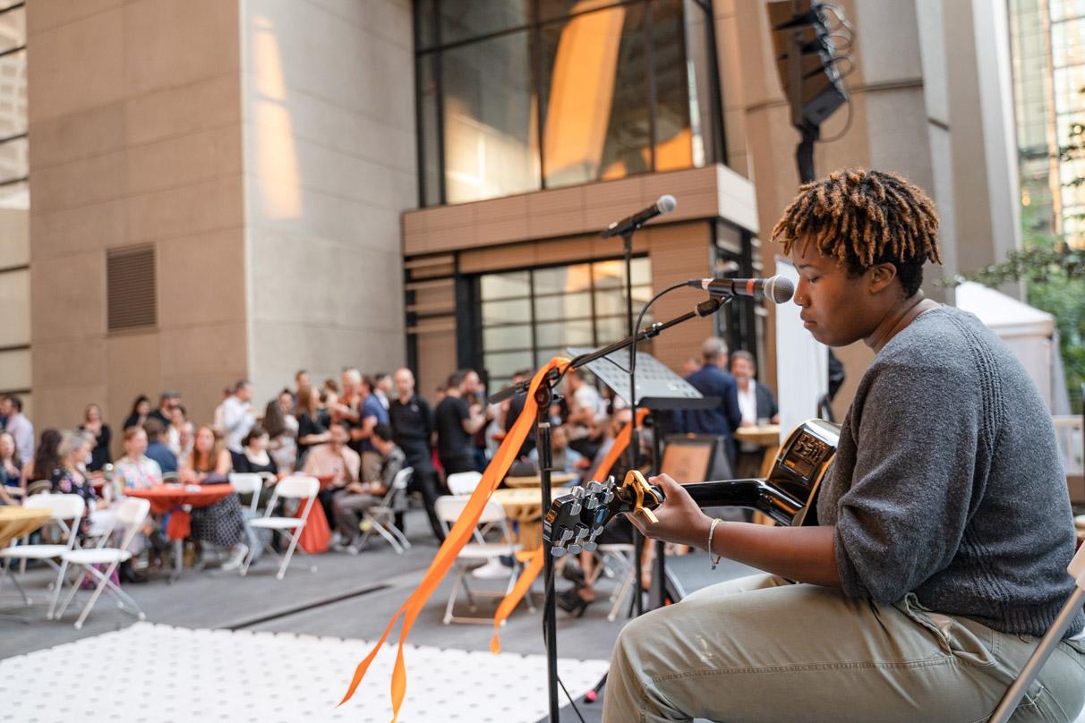 A singer performing to crowds in the public space at 2+U urban village