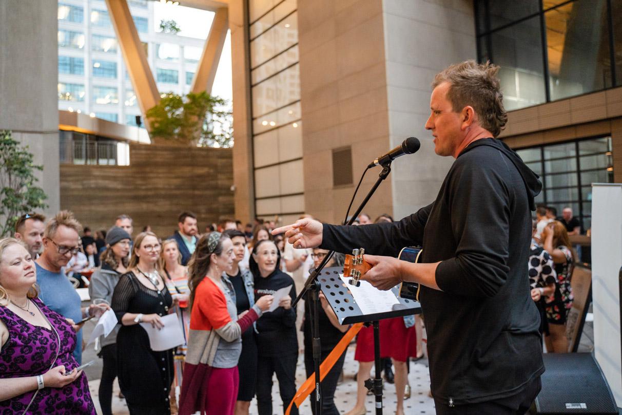 A singer performing to crowds in the public space at 2+U