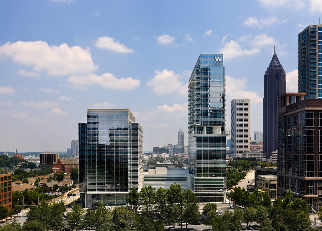 a mid arial view with building reflecting off the glass facade of W Atlanta-Downtown and The Residences building