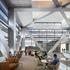 People spending their leisure time inside the ExxonMobil Energy Center surrounded by V shaped pillars and glass frame walls.