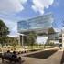 People walking around the pavement and relaxing on the park bench outside the ExxonMobil Energy Center, Houston, Texas.