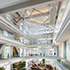 People walking inside ExxonMobil Energy Center, where a centrally suspended molecular crystal design adds aesthetic value.