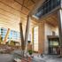 Open-air plaza at 2+U in Seattle – elevated office tower with V-shaped concrete supports, wood-clad ceilings, and vibrant pedestrian spaces.
