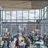 lots of open glass with people sitting on cafeteria style tables looking out at Cambridge Ma from the Akamai Headquarters building