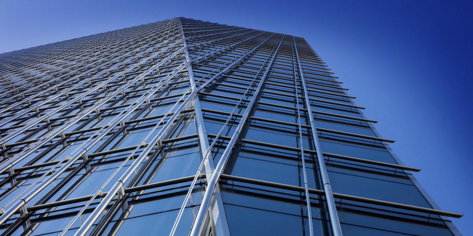 Upward view of a modern high-rise building with a glass facade and metal structural elements, showcasing sleek and innovative architectural design by Pickard Chilton