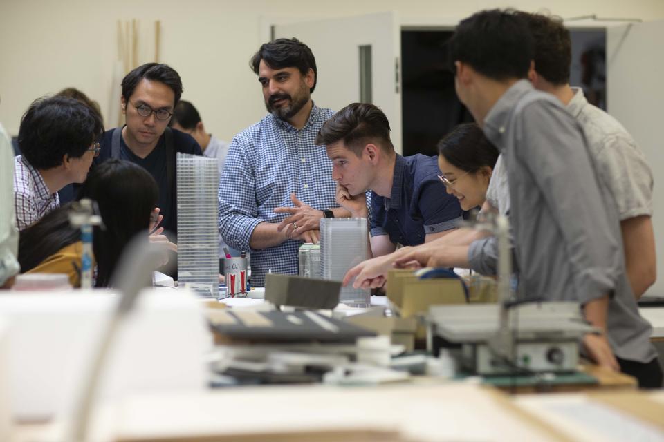 Pickard Chilton employees discussing miniature designs of a project.