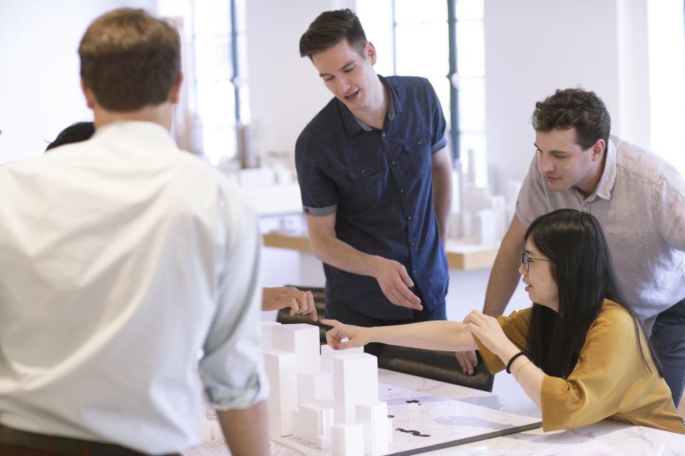 Pickard Chilton architects collaborating on a design model, showcasing teamwork and innovation in the architectural design process.