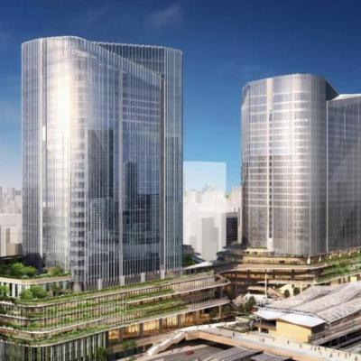 Rendering of Takanawa Gateway City in Tokyo, showcasing modern glass skyscrapers, green terraces, and the integrated railway station set to open in March 2025.